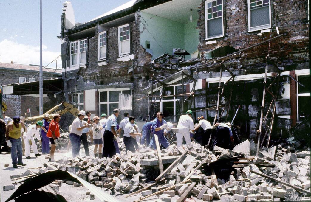 Rescue crews working to find people trapped under rubble beneath a hotel awning in Newcastle after the 1989 earthquake. Picture by Darren Pateman