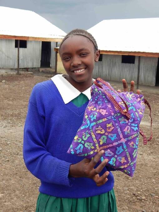 HELP: A Kenyan student holds up her Tandum sanitary kit, which will last her up to three years and costs $10. Bandicute, a Gunning retailer, has decided to donate scarf profits to this cause. Photo: supplied.