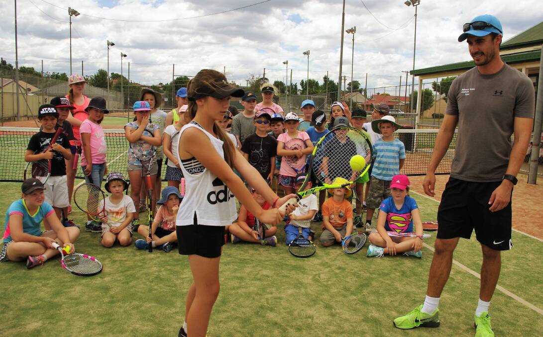 DEMONSTRATING: Goulburn Tennis Club junior squad member Chantelle Barling demonstrates a two-handed return watched by coach David Ridland during last week's tennis camp at the Bishop Street courts. Photo: Darryl Fernance