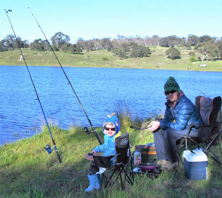 EARLY START: Isaac Moon, 5, and his dad Greg, from Goulburn, were among the early competitors to find a sheltered spot around Pejar Dam on Sunday. Photo: Darryl Fernance 