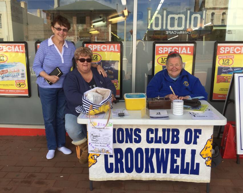 LIONS FUNDRAISING: Purchasing a ticket last week was Dawn Smith. Seated are Lionesses Alison Leary and Judith Fountain.
