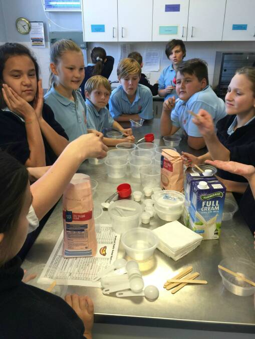 KITCHEN: Cook In A Box is an affordable way for primary schools to provide children with basic cookery skills and these student are learning how to measure, mix and cook using science, maths and method. Photo Bronwyn Haynes.