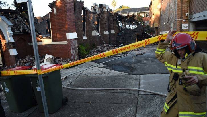 A firefighter inspects the scene at Frederick Street. Photo: Nick Moir