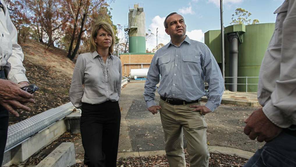 NSW Primary Industries minister Katrina Hodgkinson and Wollondilly MP Jai Rowell in the filtration plant in front of a slope burnt bare by fire. Photo: CHRISTOPHER CHAN