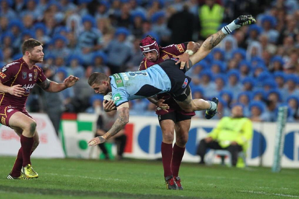 Johnathan Thurston of the QLD Maroons up ends Josh Dugan of the NSW Blues during the final game of the State of Origin 2013 series at ANZ Stadium in Sydney. Photo: Anthony Johnson 
