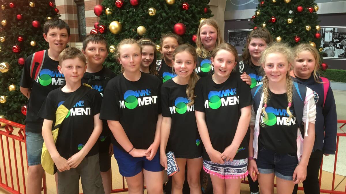 Crookwell Public Schools students (back row left to right) Connor Osborne, Riley Osborne, Bonita Holman, Mya Hape, Alana-Lee Hollis, Logan Knight, Makayla Cole and (front row left to right)  Saxon Long, Chanel Allwright, Addison Whittington, Jessie McCann and Emma Ward stop to admire the Christmas trees at Central Station after a long day rehearsing at Olympic Park.