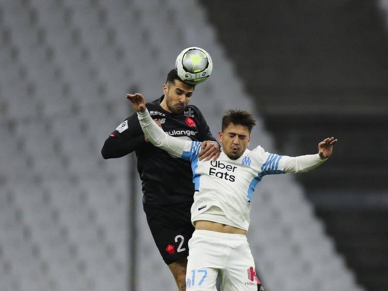 Lille's Zeki Celik beats Marseille's Cengiz Under to a header in their Ligue 1 showdown.