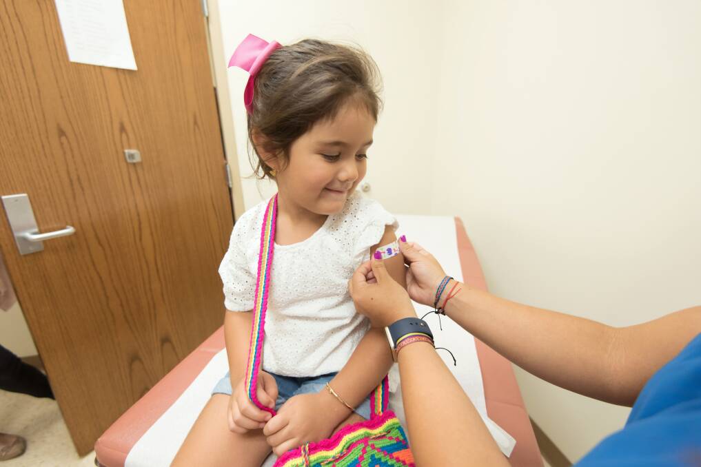 A nurse places a bandage on the injection site of a child. Photo: Centers for Disease Control and Prevention