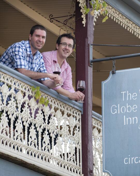 The owners: Greg Miller and David Small look over the veranda of their Georgian guesthouse built in 1847. Photo: Courtesy of The Globe Inn